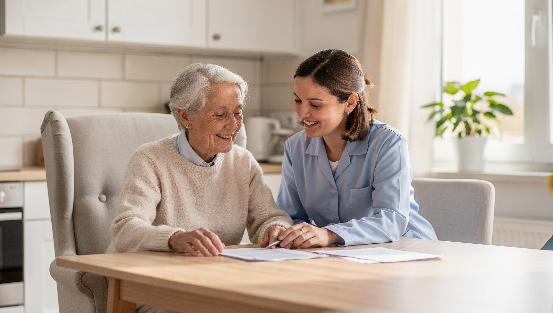 Pflegekraft und Seniorin gehen gemeinsam Papiere am Esstisch durch